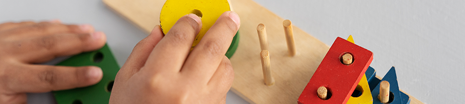 Criança pequena com brinquedos educativos.