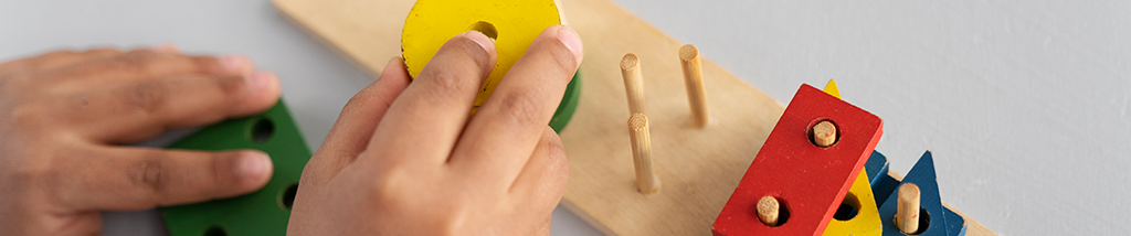 Criança pequena com brinquedos educativos.