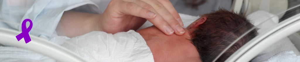 Bebê prematuro dentro de incubadora recebendo cuidado delicado de um profissional da saúde, representando a conscientização do Novembro Roxo sobre prematuridade.