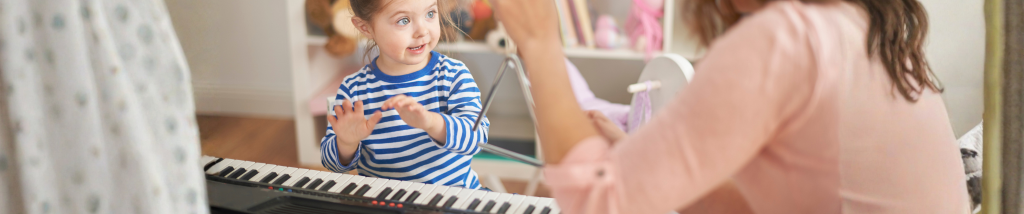 Criança participando de atividade de musicalização infantil com teclado e interação durante aula de música