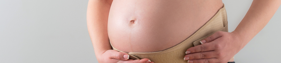 Barriga de gestante com as mãos apoiadas sobre o abdômen, representando cuidados com a saúde da mulher, gestação e preparação para o pós-parto.