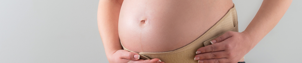 Barriga de gestante com as mãos apoiadas sobre o abdômen, representando cuidados com a saúde da mulher, gestação e preparação para o pós-parto.