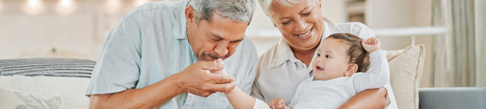 Avós brincando com um bebê no colo, fortalecendo os vínculos familiares e o desenvolvimento emocional infantil.