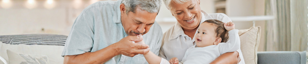 Avós brincando com um bebê no colo, fortalecendo os vínculos familiares e o desenvolvimento emocional infantil.